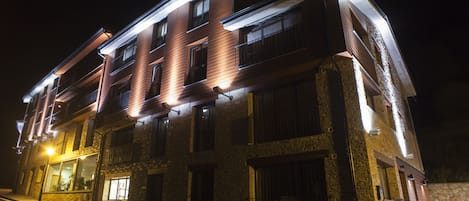 A multi-story building with a stone facade and multiple balconies.