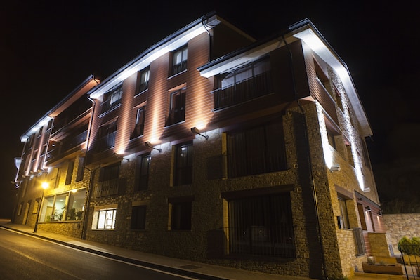 Un edificio de varios pisos con fachada de piedra y varios balcones.