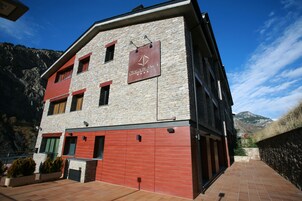 A multi-story building with a stone facade and red accents, featuring a sign that reads "Oroja Blanca."