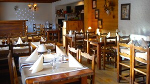 Een restaurant met houten tafels en stoelen, met een ruime indeling.