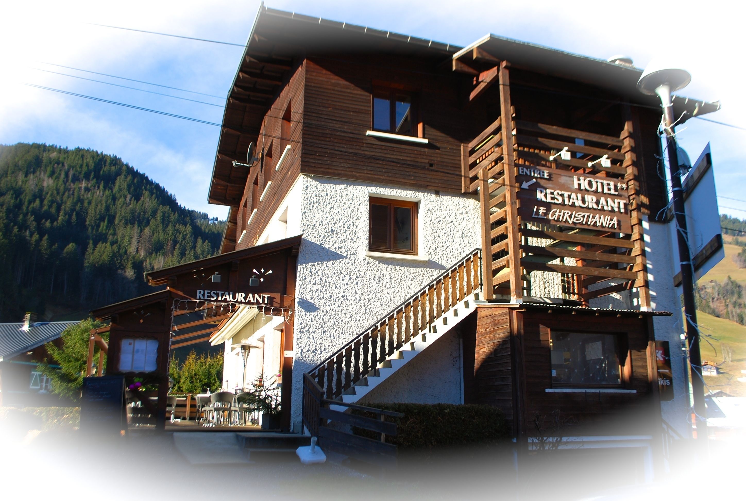 Un edificio in legno con un'insegna per hotel e ristorante.