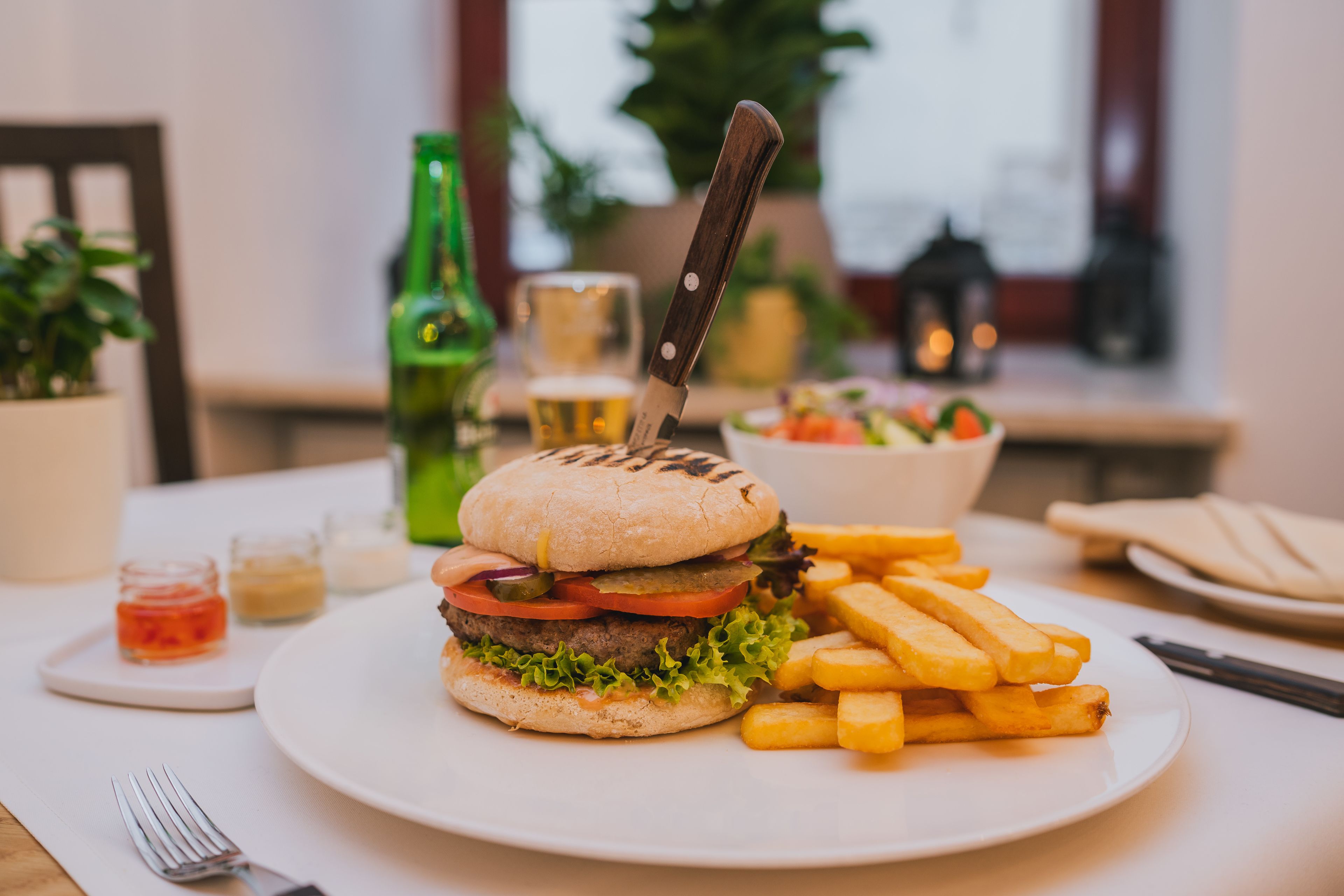 En tallrik med en hamburgare och pommes frites på ett bord.