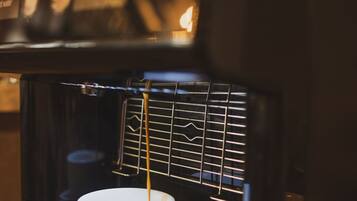 A coffee machine with a cup and saucer on the counter.