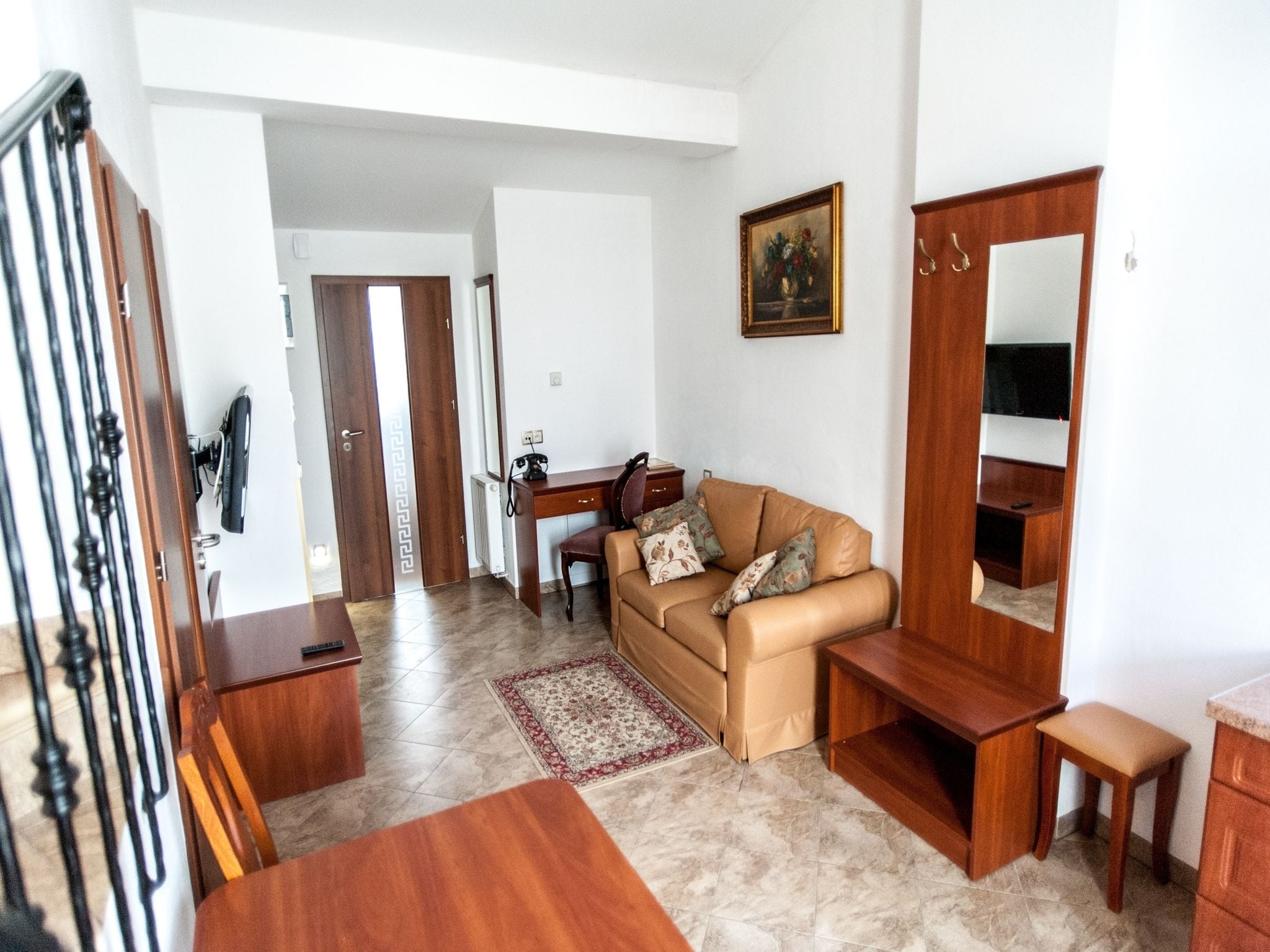 A living room with a sofa, a coffee table, a TV stand, and a wooden cabinet.