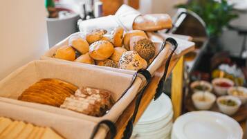 A buffet with various food items and a plant in the background.