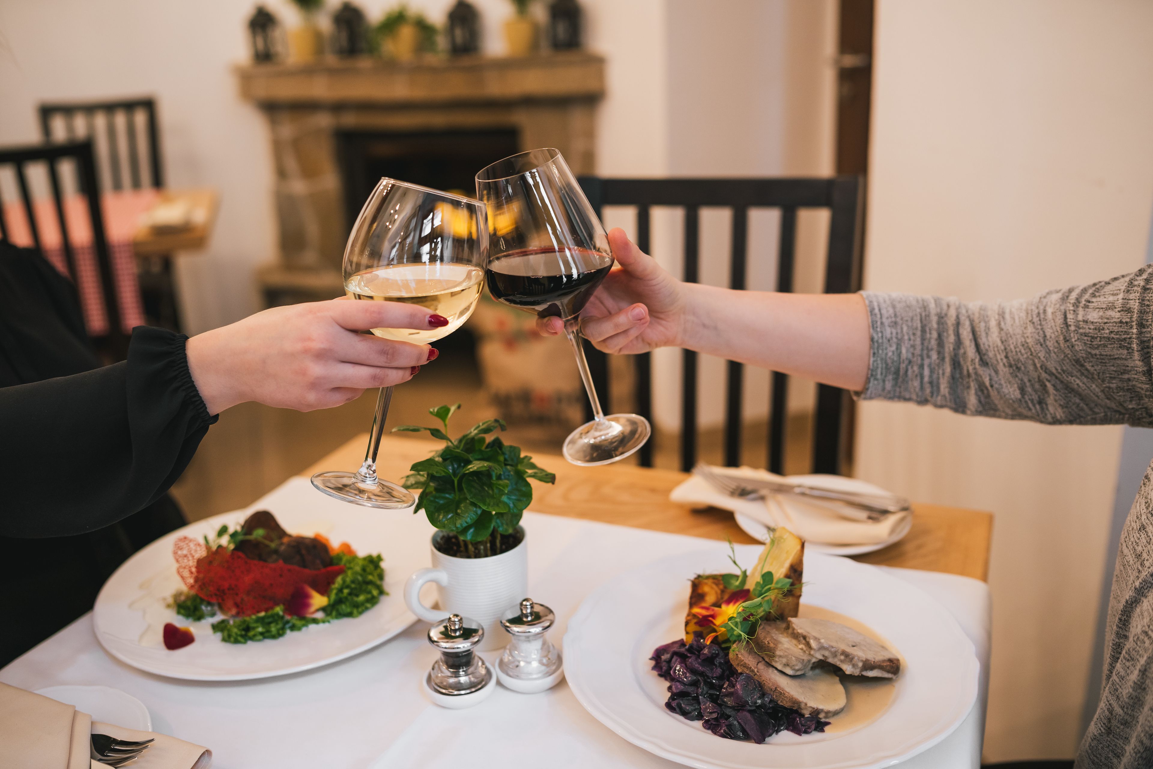 Une table à manger avec deux assiettes de nourriture, une tasse blanche et des salières et poivrières.