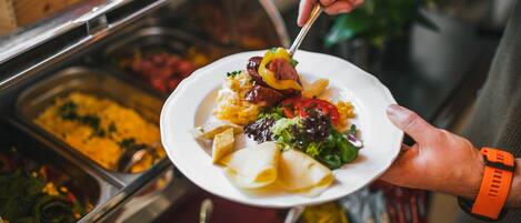 A buffet with various food options including pasta, salads, and meats.