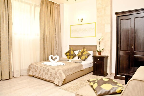 Una habitación de hotel con cama, mesita de noche, cómoda y planta en maceta.