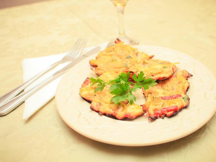 A plate of food on a table with a fork and a glass of wine.