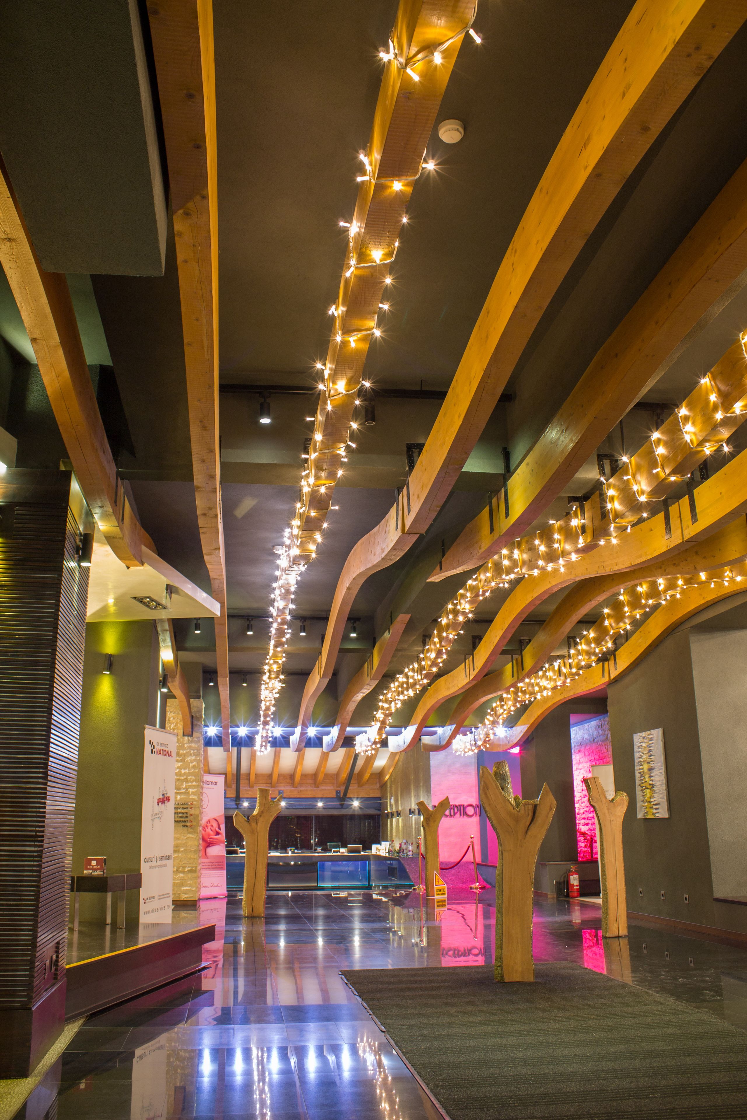 A spacious hallway with wooden beams and string lights.