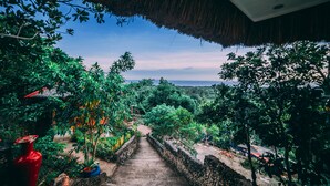 Una escalera conduce a un jardín exuberante con vista al océano.