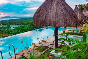 Una piscina al aire libre, sillones reclinables de piscina