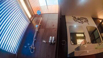 Enjoy a refreshing shower with a handheld showerhead and massager, plus ample natural light from the window.