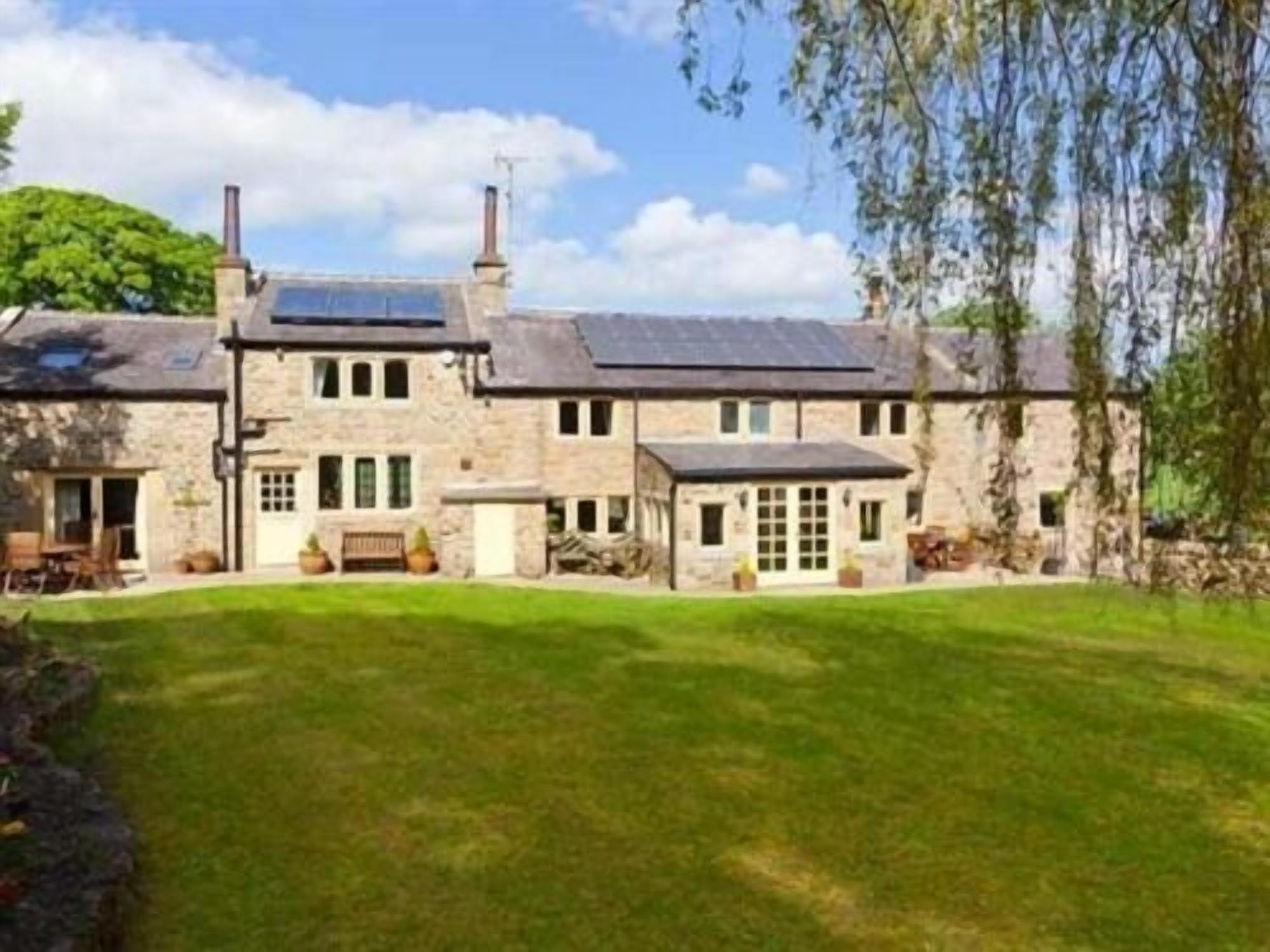 A large stone building with a spacious lawn and a small garden area.