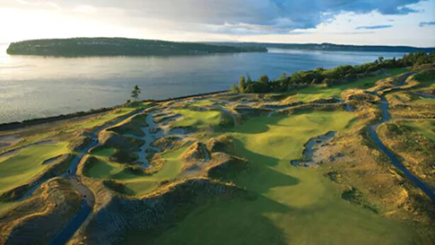 Un parcours de golf avec un lac et une île au loin.