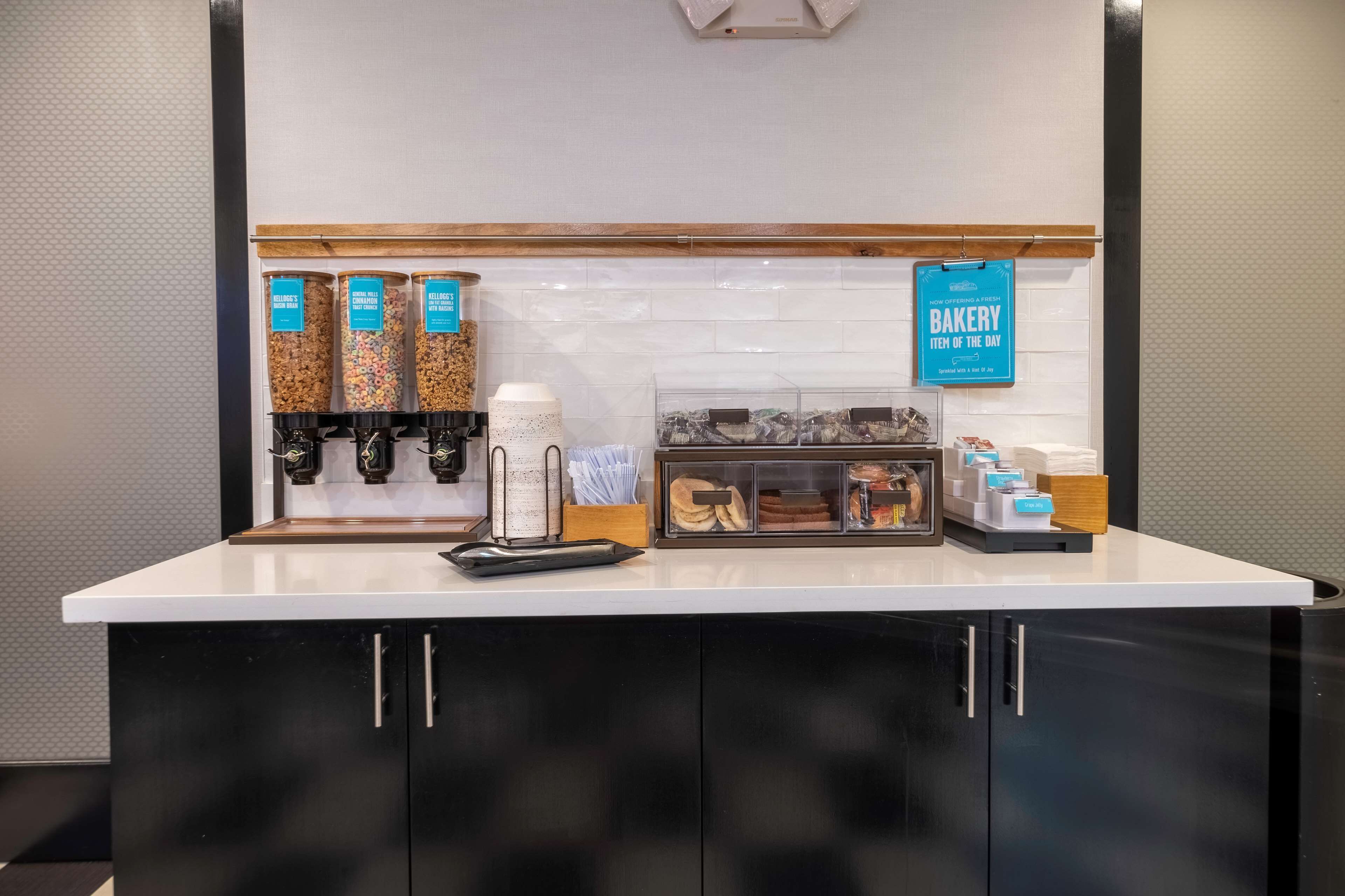 Un mostrador de panadería con diversos productos horneados y máquinas de café.