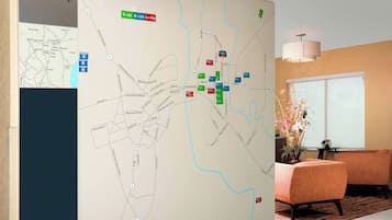 A map with various colored markers, a conference room with orange chairs, and a large window.