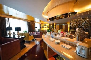 A modern hotel lobby with a curved reception desk, seating area, and a decorative wall. - Beidahuang International Hotel (Harbin)