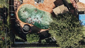 An aerial view of a swimming pool surrounded by lounge chairs and a brick wall. - Somewhere To Stay Backpackers (Highgate Hill)