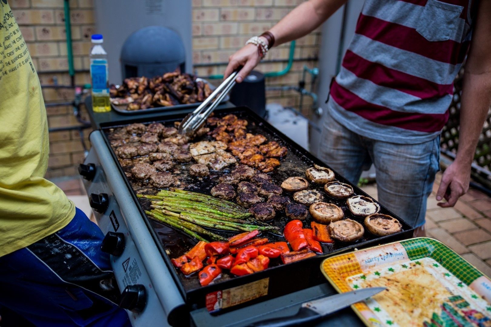 A grill with various meats and vegetables being cooked.
