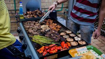 A grill with various meats and vegetables being cooked.