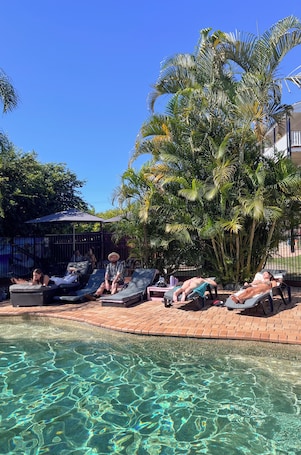 Una piscina al aire libre, sillones reclinables de piscina