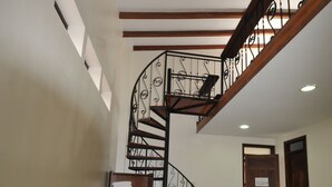 A hotel room with two beds, a wooden staircase, and a view of the outside. - Hotel San Julian (Guadalajara de Buga)