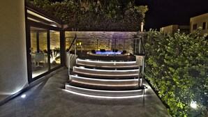 A modern outdoor staircase leading to a hot tub area, surrounded by lush greenery and a stone wall. - Room & Breakfast Aloe (San Vito Lo Capo)