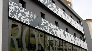 A building with a modern facade featuring large windows and a geometric pattern on the upper level. - Rossio Hotel (Portalegre)