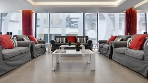 A modern living room with grey sofas, red cushions, and a white coffee table. - Rossio Hotel (Portalegre)