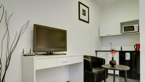 Una cuina moderna amb televisió de pantalla plana, microones i cafetera.