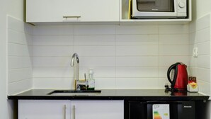 Cuina compacta amb microones, rentapelats i bullidor.