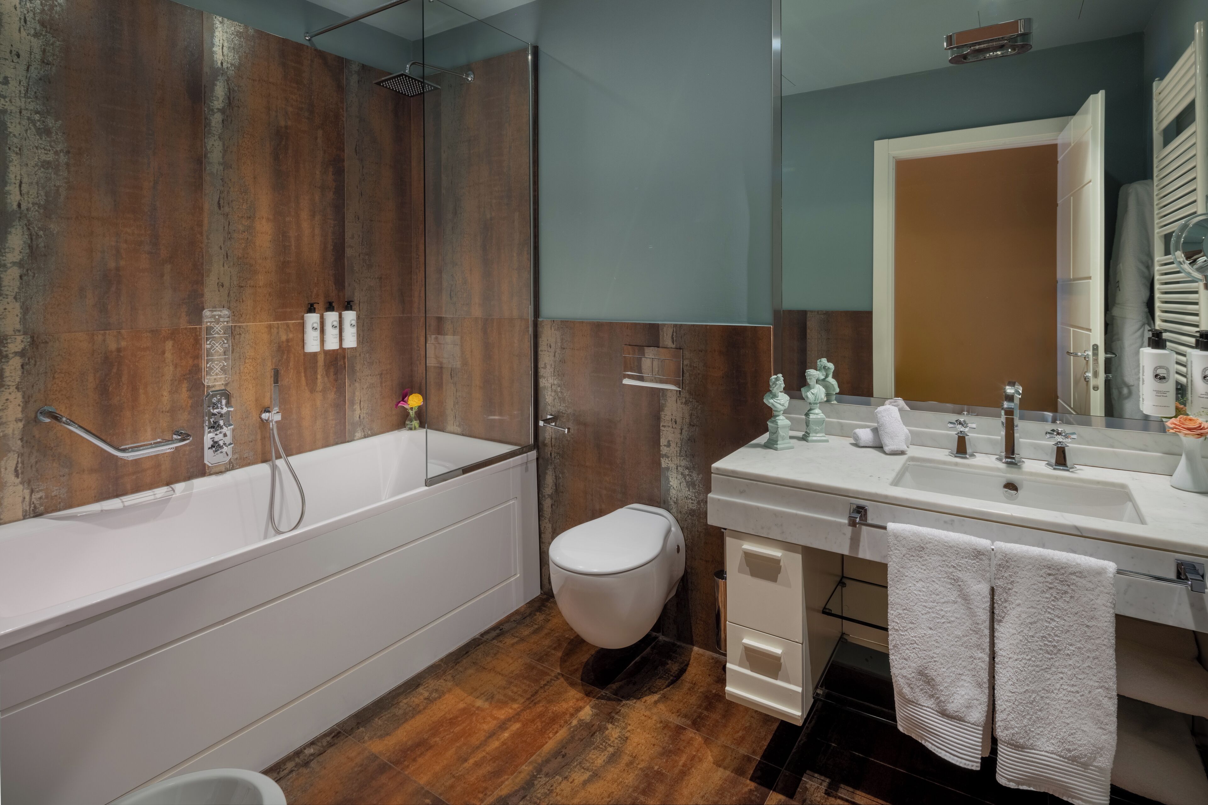 A modern bathroom with a large bathtub, a toilet, and a vanity with a mirror.