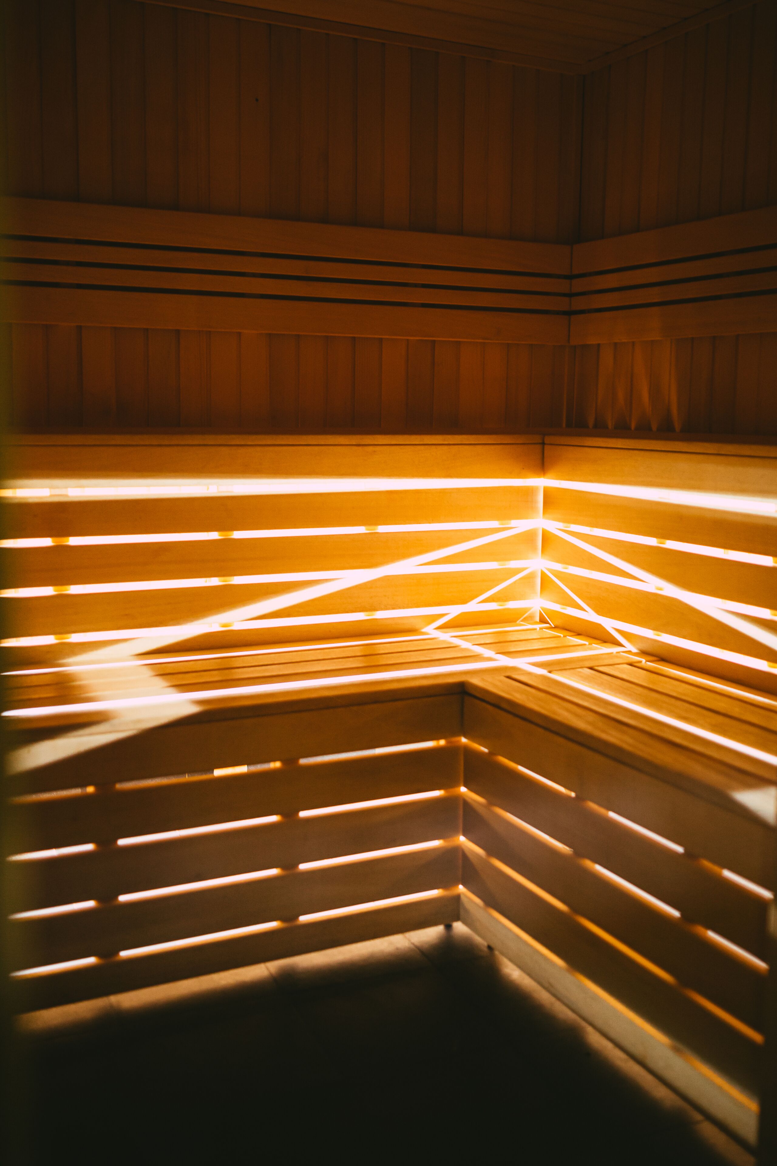 Un sauna aux murs en bois et aux bancs à lattes.