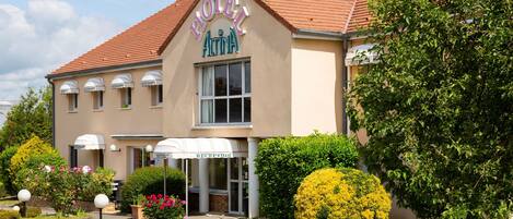 A hotel with a reception area, a parking lot, and well-maintained landscaping.