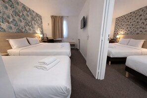 A hotel room with three beds, a desk, a chair, a TV, and a window with curtains. - Hôtel Altina (Pacy-sur-Eure)