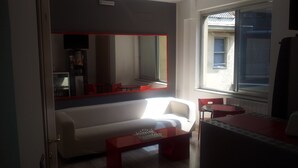 A modern living room with a sofa, a coffee table, and a large mirror. - Scacco Matto (Milan)