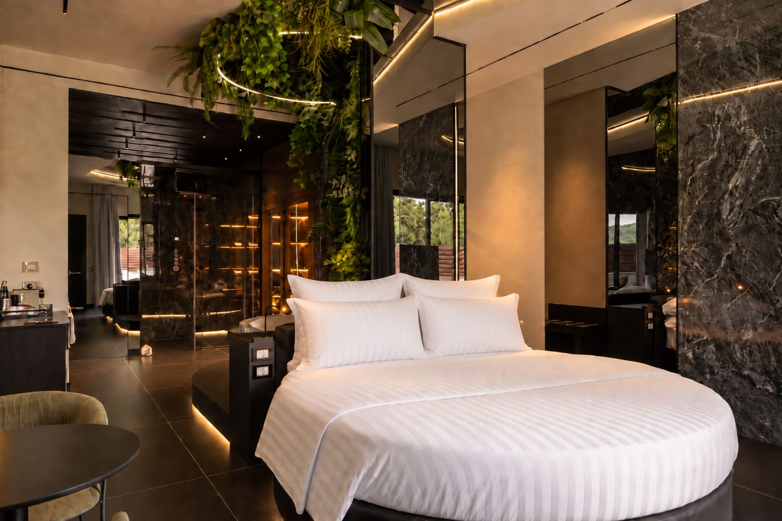 A modern hotel room with a large bed, a seating area, and a view of the outdoors.
