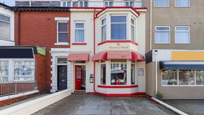 A corner building with a red and white facade, featuring a sign for 'Almeria Hotel' and a visible entrance. - The Almeria (Blackpool)