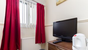 A room with a television, a remote control, a kettle, and a radiator. - The Almeria (Blackpool)