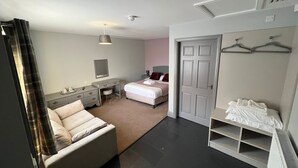 A modern bedroom with a bed, bedside table, dresser, and a walk-in closet with shelves.