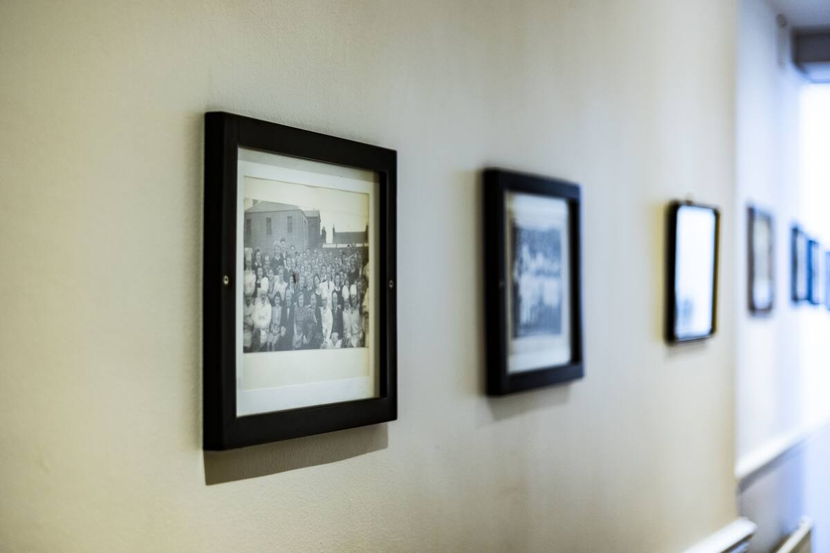 A hallway with framed photographs on the wall.