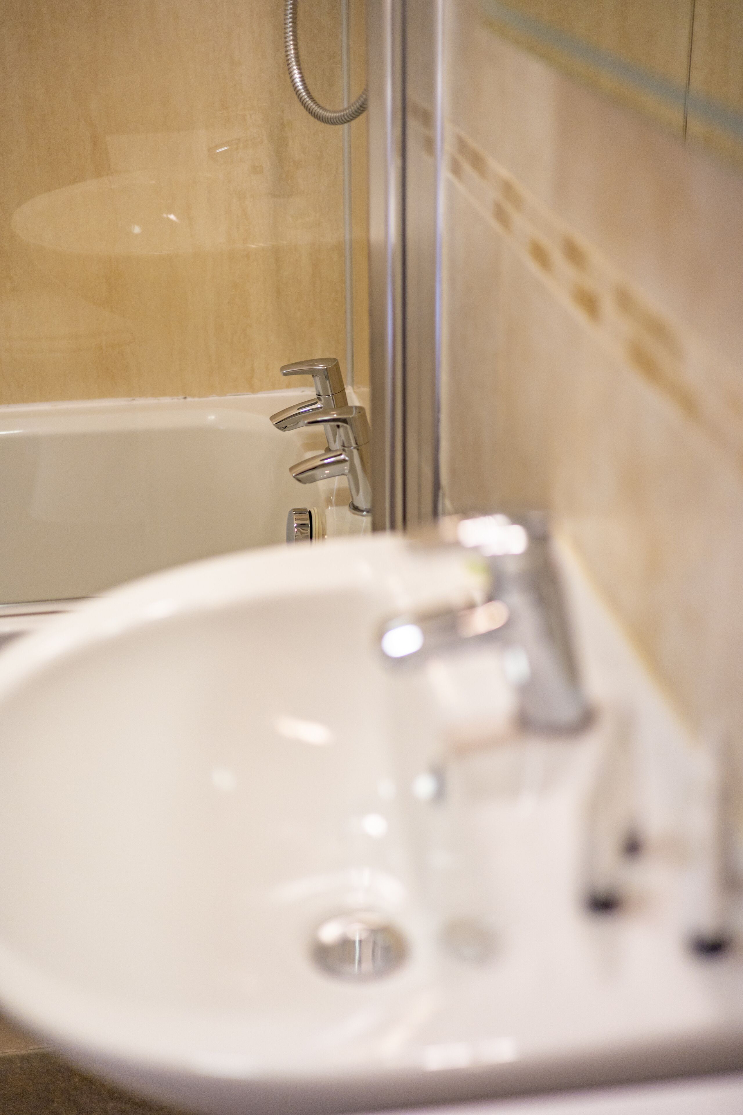 A bathroom with a white sink and a bathtub.