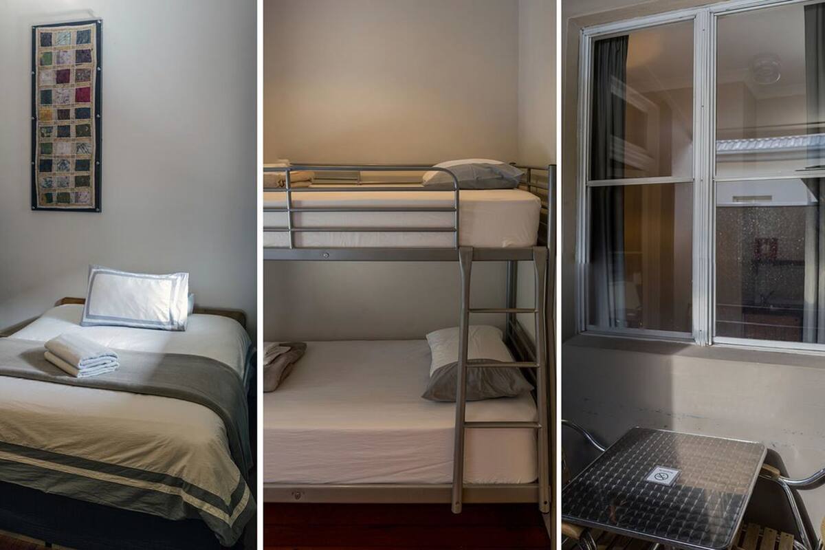 A dormitory room with bunk beds, a desk, and a window.