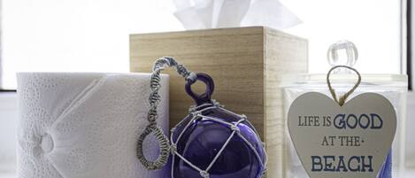 Eine Taschentuchbox, eine dekorative Glasverzierung und ein herzförmiger Kerzenständer mit Strandmotiv.