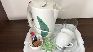 Ein Tablett mit einem Milchkännchen, zwei Gläsern, einer Tasse, einer Schüssel mit Snacks und Milchpaketen.