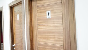 Zwei Holztüren mit einem Schild, das eine Damentoilette kennzeichnet.