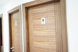 Two wooden doors with a sign indicating a ladies' restroom.