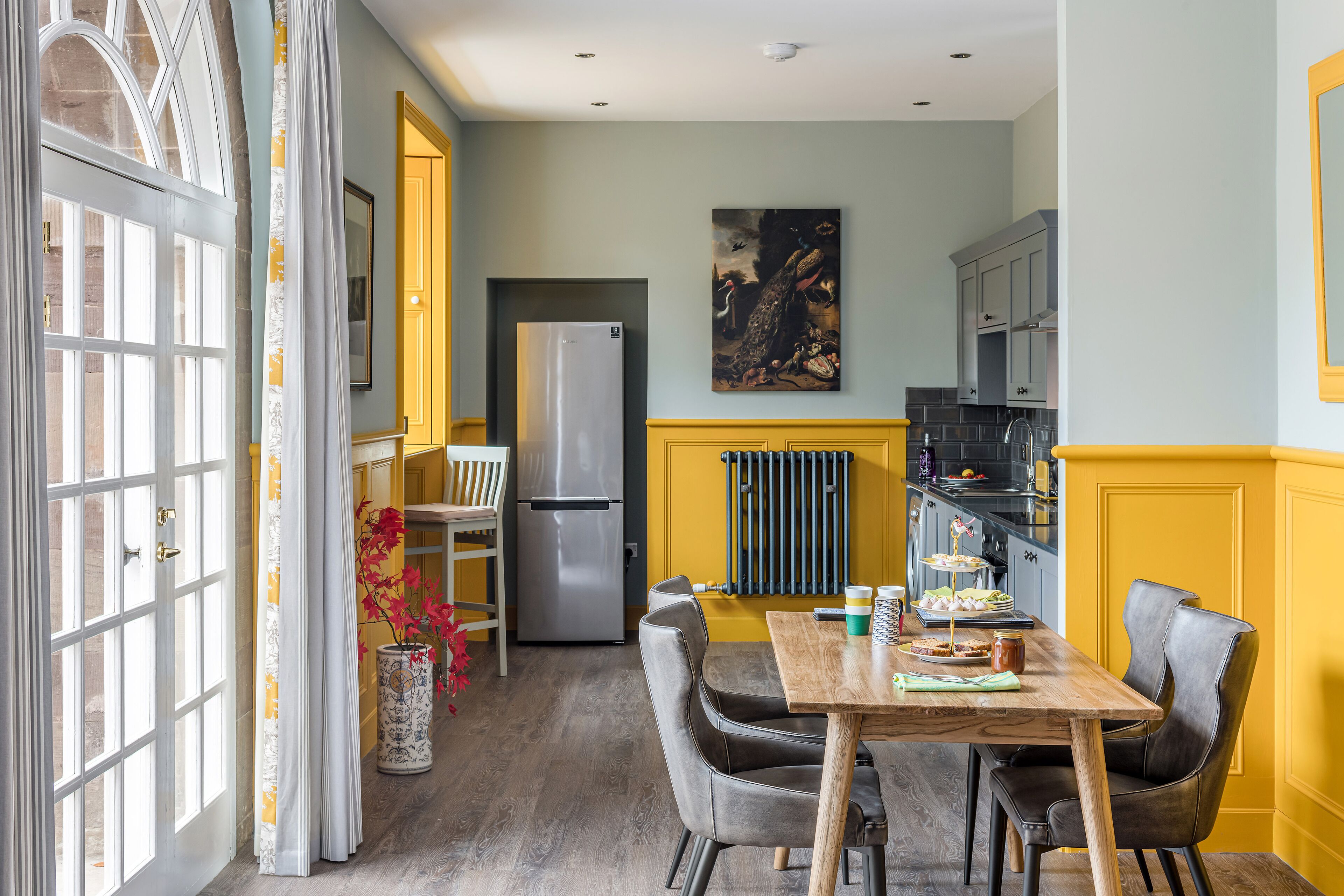 Une cuisine équipée d’une table à manger, de chaises, d’un réfrigérateur et d’un radiateur.