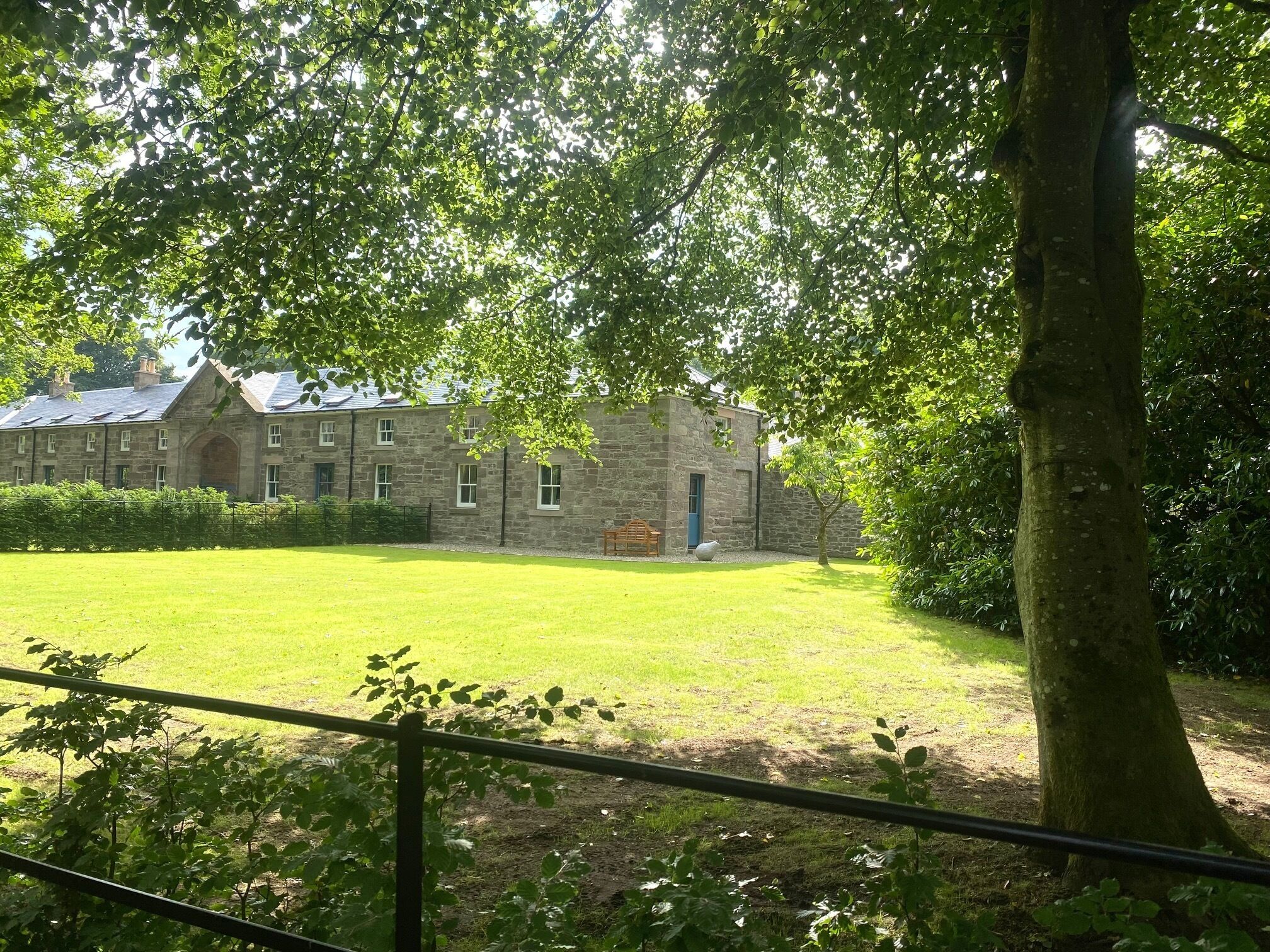 A stone building with a large lawn in front.